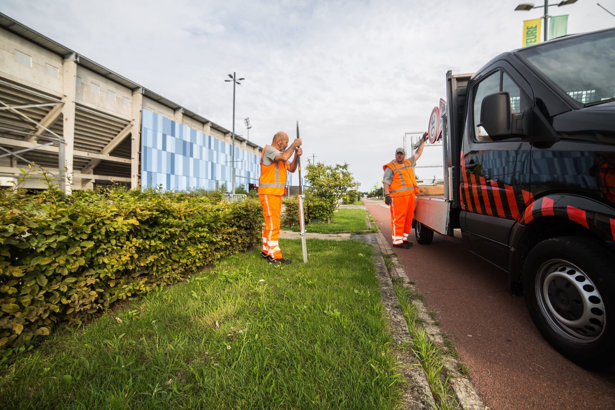 Team van traffic management specialisten plaatst verkeersborden langs de weg bij wegwerkzaamheden.