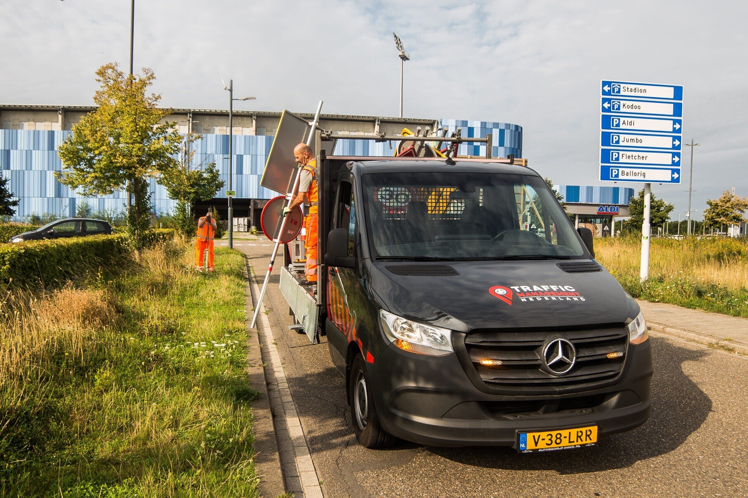 Team van traffic management specialisten plaatst verkeersborden langs de weg bij wegwerkzaamheden.