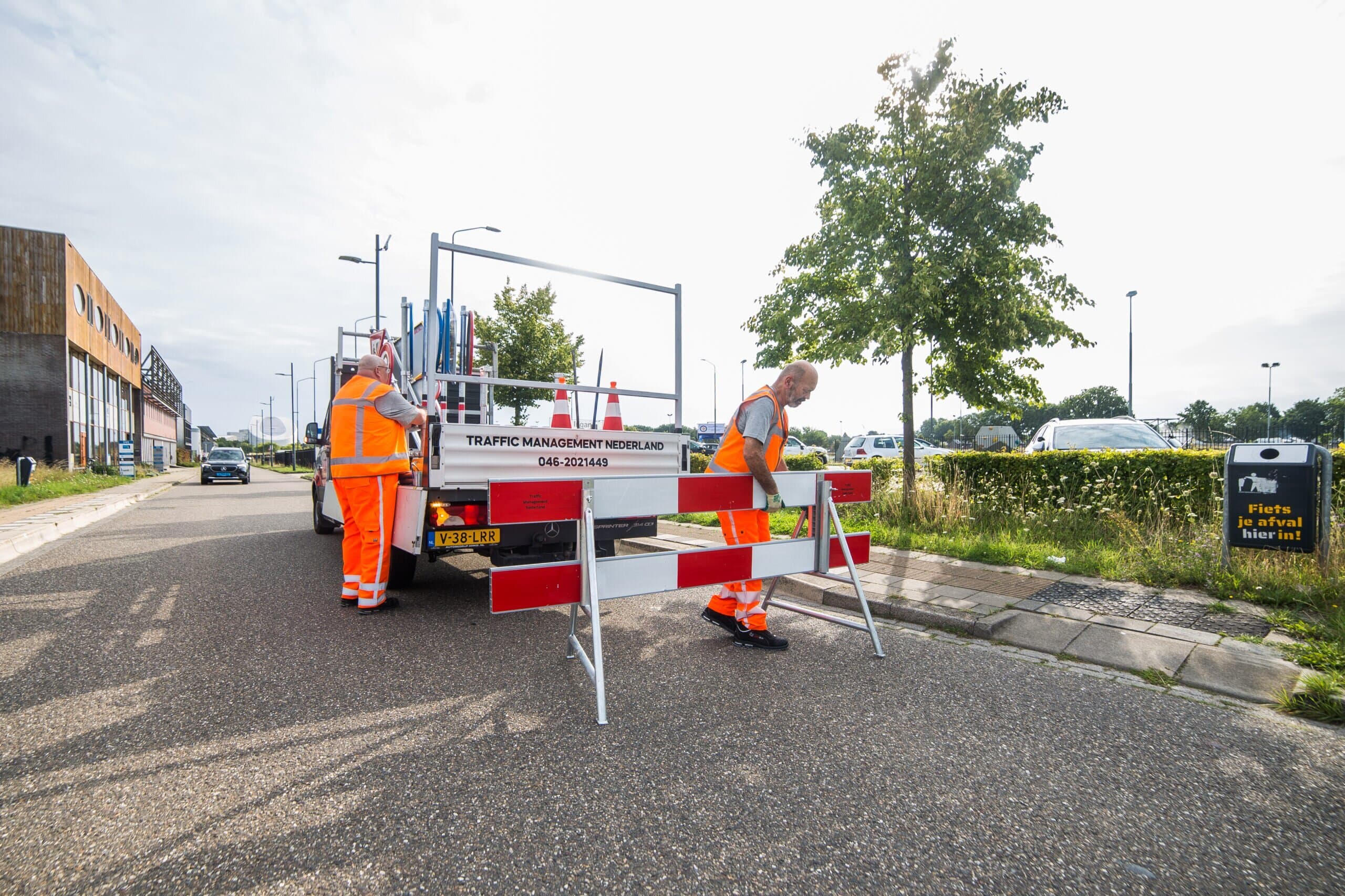 Team van traffic management specialisten plaatst verkeersborden langs de weg bij wegwerkzaamheden.